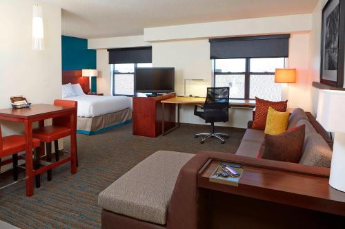 a hotel room with a couch and a bed and a desk at Residence Inn Minneapolis St. Paul/Roseville in Roseville