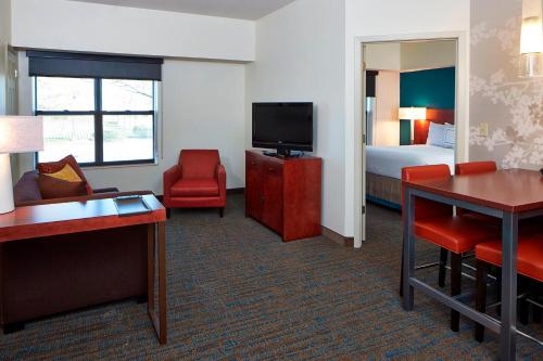 a hotel room with a bedroom with a bed and a television at Residence Inn Minneapolis St. Paul/Roseville in Roseville