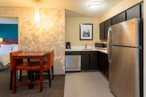 a small kitchen with a table and a refrigerator at Residence Inn Minneapolis St. Paul/Roseville in Roseville