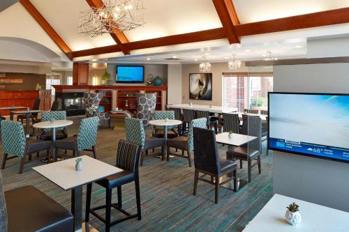 a restaurant with tables and chairs and a flat screen tv at Residence Inn Minneapolis St. Paul/Roseville in Roseville