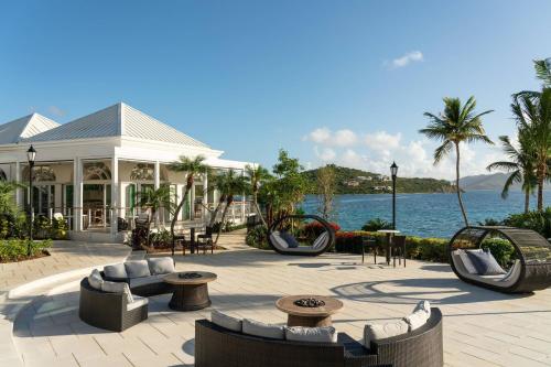 a resort with couches and chairs and the water at The Ritz-Carlton St. Thomas in Benner