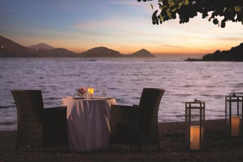 a table with chairs and wine glasses on the beach at The Ritz-Carlton St. Thomas in Benner