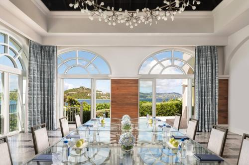a dining room with a glass table and chairs and large windows at The Ritz-Carlton St. Thomas in Benner