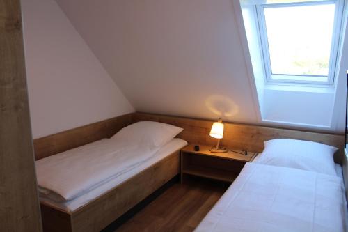 two beds in a small room with a window at LA 4g - Ferienreihenhaus in Schottwarden
