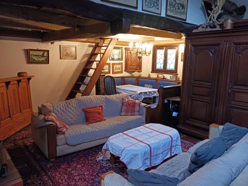 sala de estar con sofá y escalera en maison Alsacienne du 18eme siècles, en Brumath