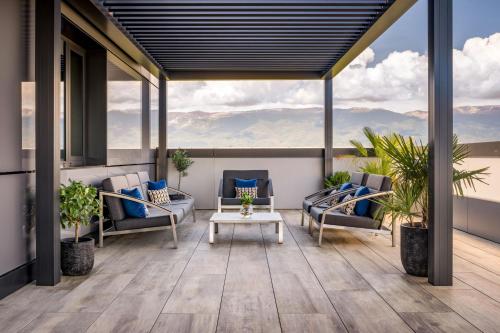 a patio with couches and a table on a balcony at Geneva Marriott Hotel in Geneva