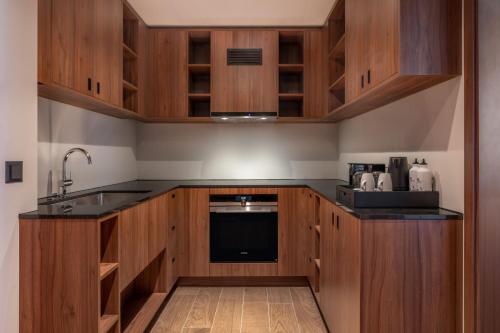 a kitchen with wooden cabinets and a sink at Geneva Marriott Hotel in Geneva