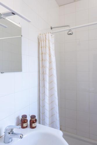 une salle de bain avec un lavabo et un rideau de douche dans l'établissement Hotel De Belgique à Menton, à Menton