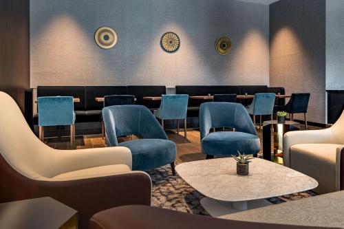 a waiting room with blue chairs and tables at Geneva Marriott Hotel in Geneva