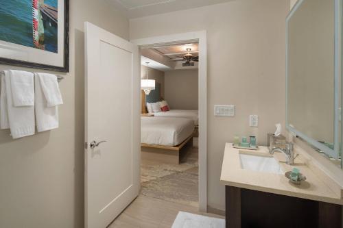 a bathroom with a sink and a bedroom with a bed at Waterline Villas & Marina, Autograph Collection in Holmes Beach