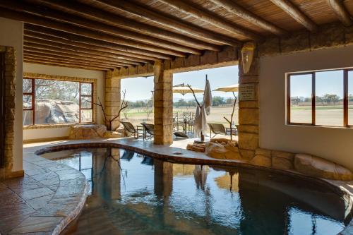 una piscina in una casa con piscina di Zebula Golf Estate and Spa - Zebula Golfers Lodge a Mabula