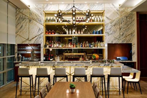 a bar in a restaurant with tables and chairs at AC Hotel by Marriott Portland Downtown, OR in Portland