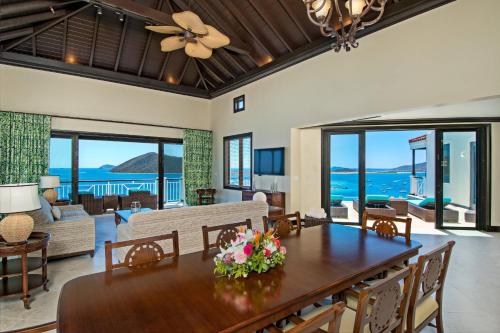 a dining room with a table and a living room at Scrub Island Resort, Spa & Marina in The Mill