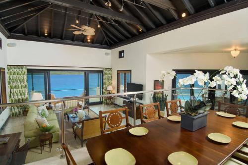 a dining room with a table and a view of the ocean at Scrub Island Resort, Spa & Marina in The Mill