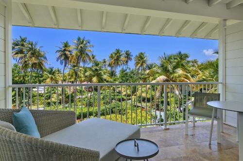 a porch with a couch and a balcony with palm trees at St. Regis Bahia Beach Resort, Puerto Rico in Rio Grande
