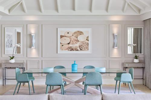 a dining room with a glass table and blue chairs at St. Regis Bahia Beach Resort, Puerto Rico in Rio Grande