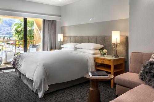 um quarto de hotel com uma cama grande e um sofá em Renaissance Palm Springs Hotel em Palm Springs