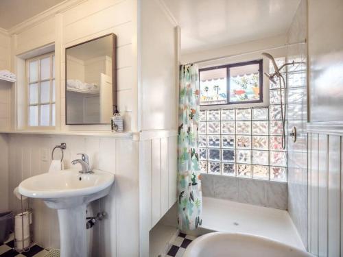 a bathroom with a sink and a toilet and a window at Relaxing 3 bedroom Santa Cruz house, 5min to beach in Santa Cruz
