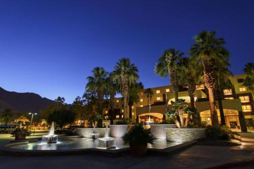 a building with palm trees and a fountain at night at Renaissance Palm Springs Hotel in Palm Springs
