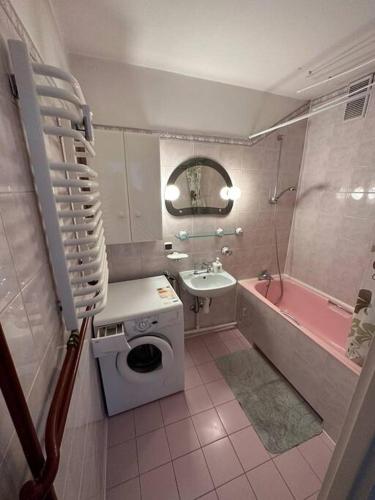 uma casa de banho com uma banheira rosa, um lavatório e um WC. em Mieszkanko na rynku Rzeszowskim em Rzeszów