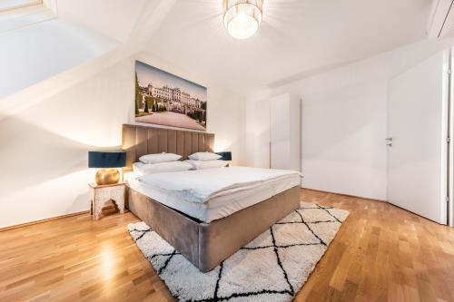 - une chambre blanche avec un grand lit et un tapis dans l'établissement Smile Apartments Döbling, à Vienne