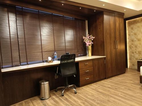 a office with a desk with a chair and a vase of flowers at Retrieve Health & Wellness in Cochin