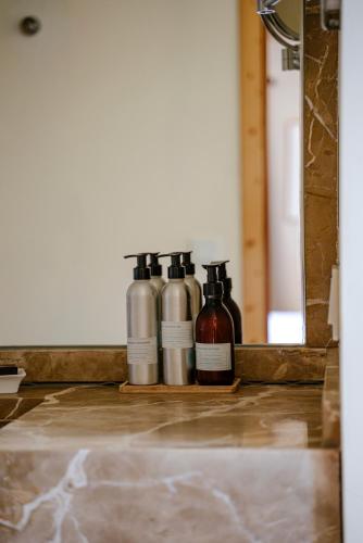a group of three bottles sitting on a counter in front of a mirror at Finca Gomera - Agroturismo Hotel in Cala Pi