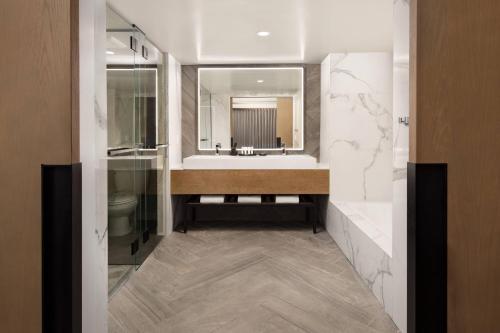 a bathroom with a sink and a large mirror at Santa Clara Marriott in Santa Clara