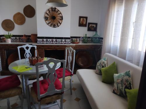 ein Wohnzimmer mit einem Tisch und einem Sofa in der Unterkunft Casa Primavera in Setenil de las Bodegas