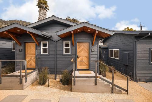 a black house with wooden doors in a yard at Mini Shortboard Room with a Queen Bed in Stinson Beach