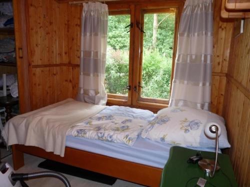 Cama pequeña en habitación con ventana en Ferienhaus mit eigenem Strand, en Barnówko