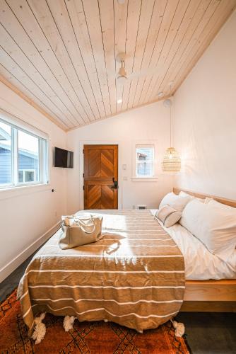 ein Schlafzimmer mit einem großen Bett und einer Handtasche darauf in der Unterkunft Mini Shortboard Room with a Queen Bed in Stinson Beach