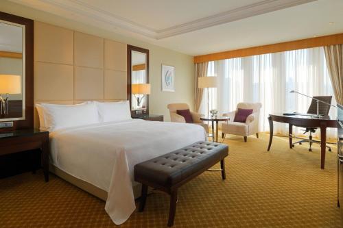 una habitación de hotel con una cama grande y un piano en JW Marriott Hotel Ankara en Ankara
