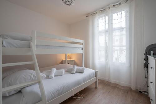 - une chambre blanche avec des lits superposés et une fenêtre dans l'établissement *Disneyland-Paris* 7pers, Wifi, Netflix, Parking, à Serris