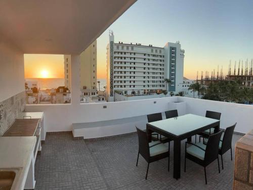 マサトランにある2br/2ba Condo 1 block to ocean! - Unit #5の建物の上にテーブルと椅子が置かれたバルコニー