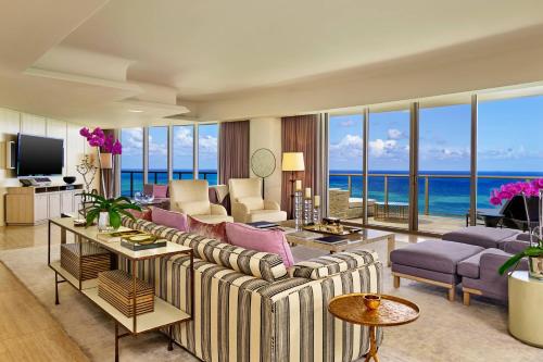 ein Wohnzimmer mit einem Sofa, Stühlen und Meerblick in der Unterkunft The St. Regis Bal Harbour Resort in Miami Beach