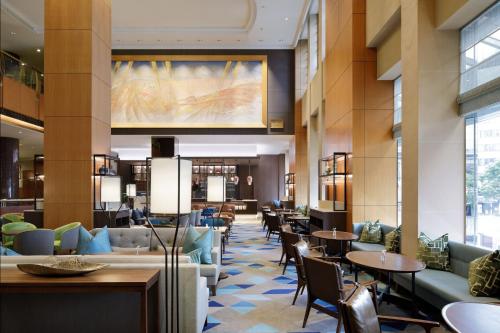a lobby of a hotel with tables and chairs at Yokohama Bay Sheraton Hotel and Towers in Yokohama