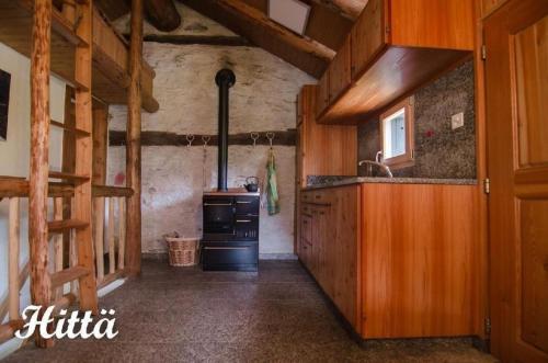 uma cozinha com um fogão e um lavatório num quarto em Alphütte "Hittä" in Simplon-Dorf im sonnigen Wallis em Simplon Dorf