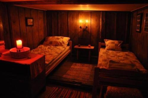 Habitación con 2 camas y una vela sobre una mesa en Zimmer in uriger rustikalen Alphütte auf bewirtschafteter Alp hoch in den Bergen, inkl VP en Leukerbad