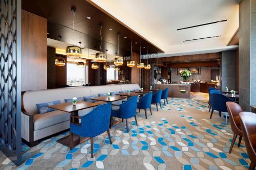 a dining room with tables and blue chairs at Yokohama Bay Sheraton Hotel and Towers in Yokohama