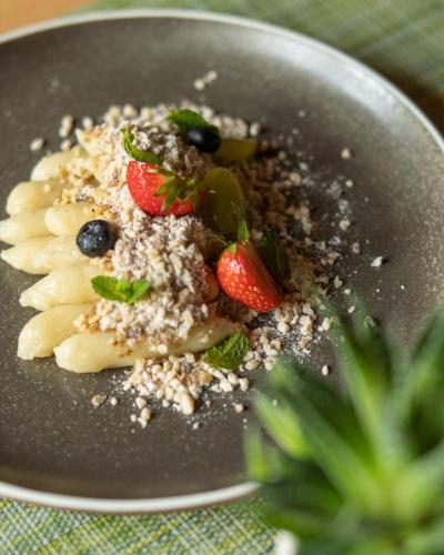 a plate of pasta with fruit and nuts on a table at Penzión Pegas in Bratislava