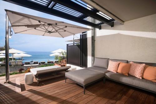 a patio with a couch and an umbrella at Wailea Beach Resort - Marriott, Maui in Wailea