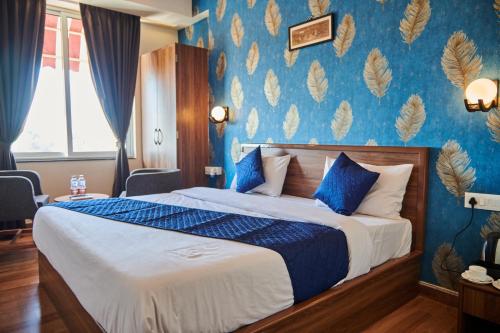 a bedroom with a bed with a blue wall at The Sarai, Hotel in Jaipur