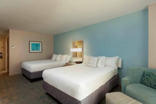 a hotel room with two beds and a couch at Courtyard by Marriott Isla Verde Beach Resort in San Juan