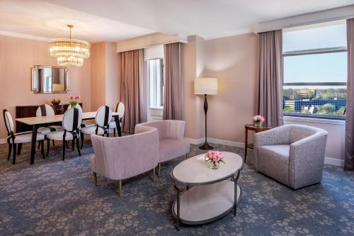 a living room with a table and chairs and a dining room at Peoria Marriott Pere Marquette in Peoria