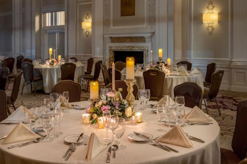 a banquet room with tables with white table cloths and candles at Peoria Marriott Pere Marquette in Peoria