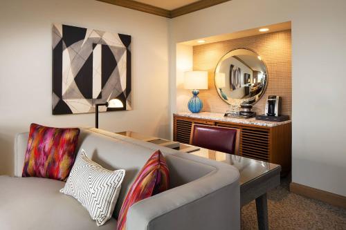 The Canyon Suites at The Phoenician, a Luxury Collection Resort, Scottsdale في سكوتسديل: غرفة معيشة مع أريكة ومرآة