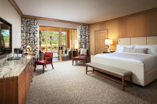 スコッツデールにあるThe Canyon Suites at The Phoenician, a Luxury Collection Resort, Scottsdaleのベッド、デスク、椅子が備わるホテルルームです。