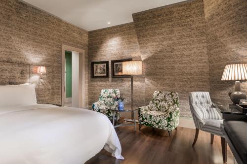 a hotel room with a bed and two chairs at Santo Mauro, a Luxury Collection Hotel, Madrid in Madrid