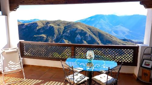 a table on a balcony with a view of a mountain at Apartamento en el corazon de las Alpujarras in Carataunas